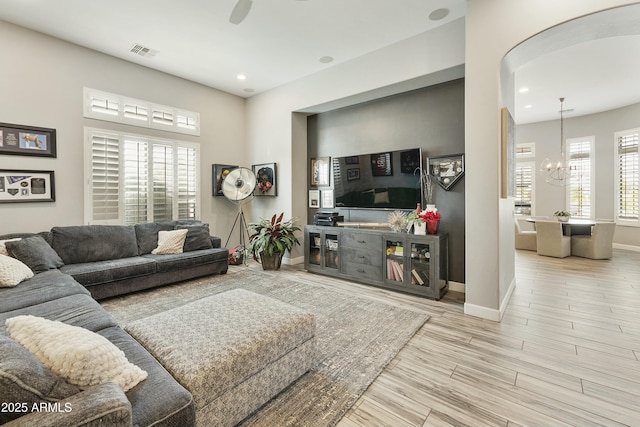 living area with visible vents, a healthy amount of sunlight, baseboards, and wood finished floors