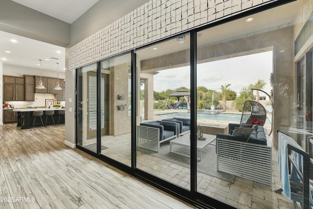 doorway to outside with light wood finished floors and recessed lighting