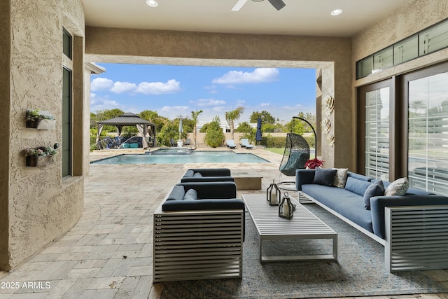 view of patio with a gazebo, an outdoor pool, ceiling fan, and outdoor lounge area