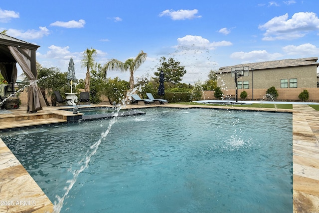 view of pool featuring a pool with connected hot tub and fence