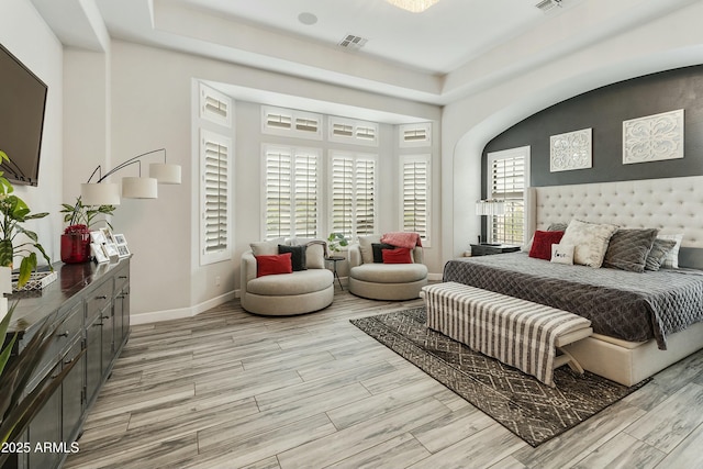 bedroom featuring visible vents, baseboards, and light wood finished floors