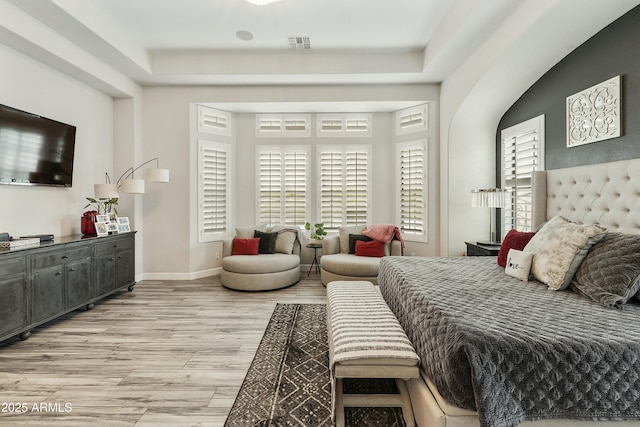 bedroom with light wood-type flooring, visible vents, and baseboards