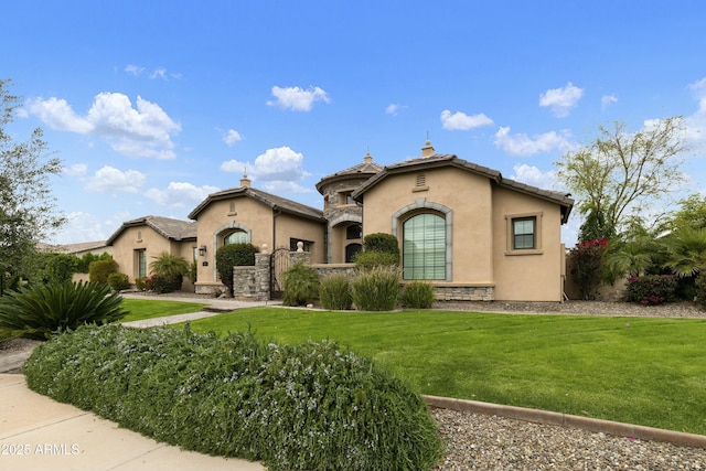 mediterranean / spanish-style house with stucco siding, stone siding, a front lawn, and a tiled roof