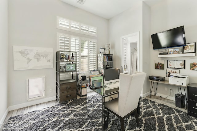 office featuring visible vents, baseboards, and wood finished floors