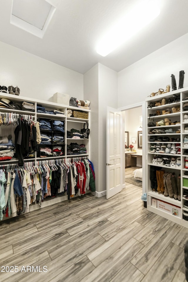 walk in closet featuring attic access and wood finished floors