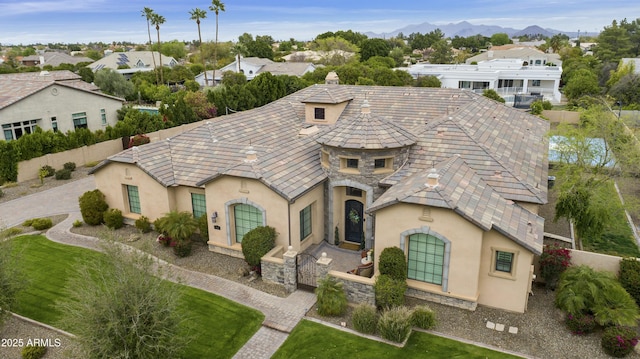 view of front of property with fence, stone siding, and stucco siding