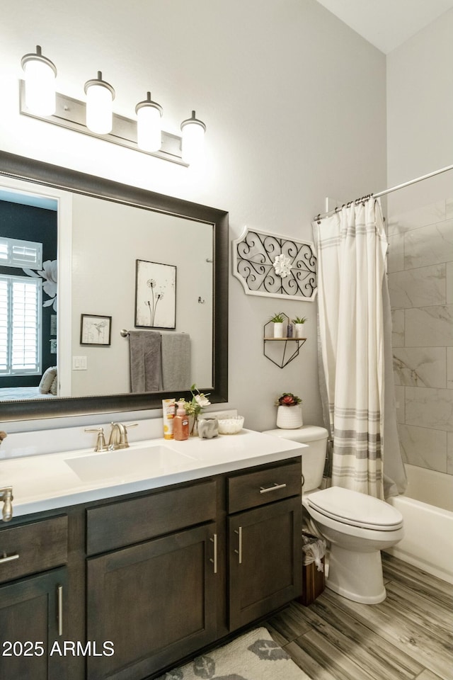 full bathroom featuring toilet, vanity, wood finished floors, ensuite bath, and shower / bathtub combination with curtain