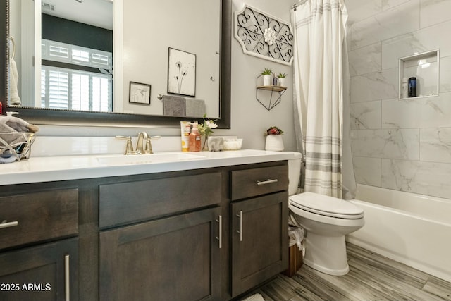 full bath with shower / tub combo, toilet, wood finished floors, and vanity