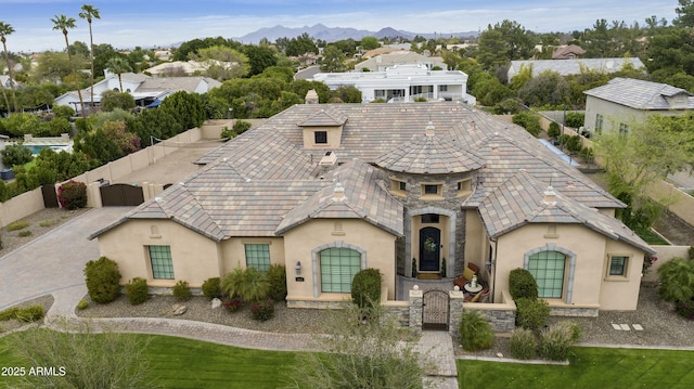 view of front of property featuring a gate, stucco siding, stone siding, and fence