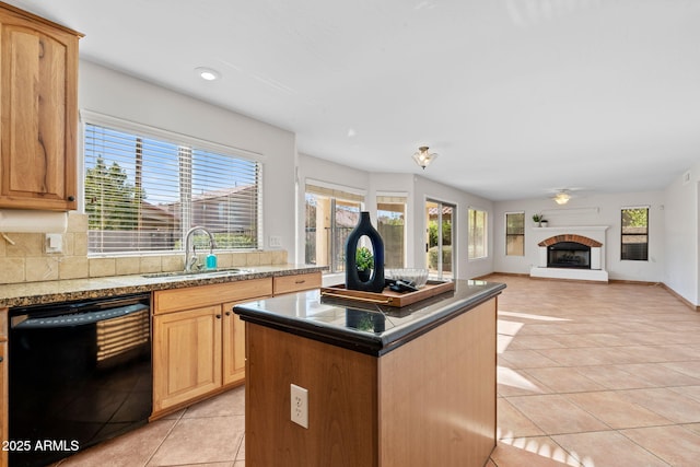 kitchen with sink, a center island, a healthy amount of sunlight, and black dishwasher