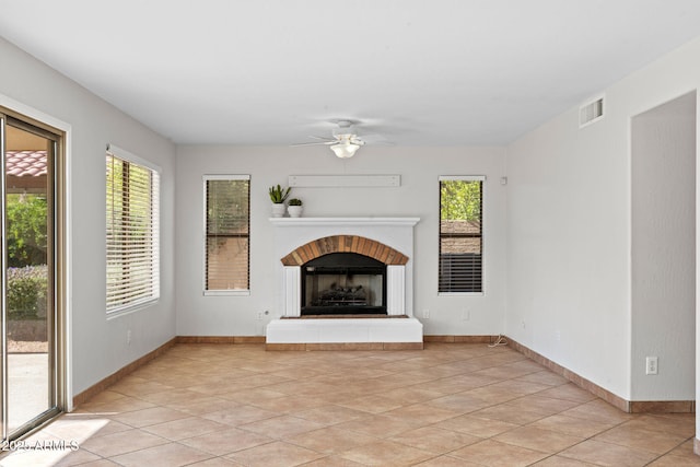 unfurnished living room featuring ceiling fan, a wealth of natural light, and light tile patterned floors