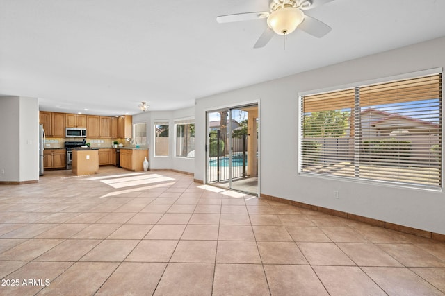 unfurnished living room with ceiling fan and light tile patterned floors