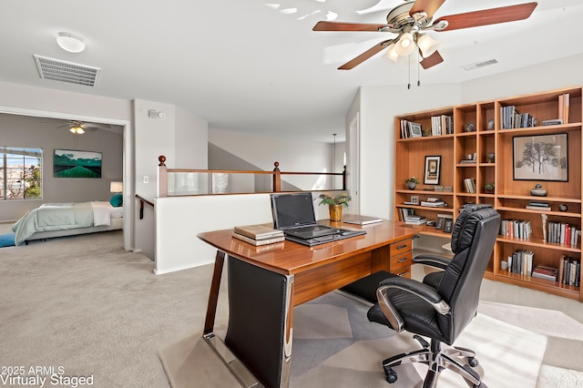 carpeted office space featuring ceiling fan