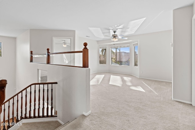 hallway with a skylight and light colored carpet