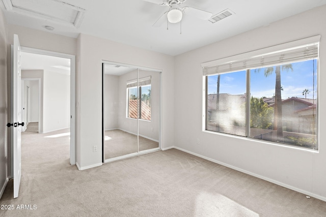 unfurnished bedroom with a closet, ceiling fan, and light colored carpet