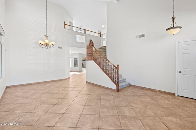 tiled foyer entrance with a towering ceiling and a chandelier