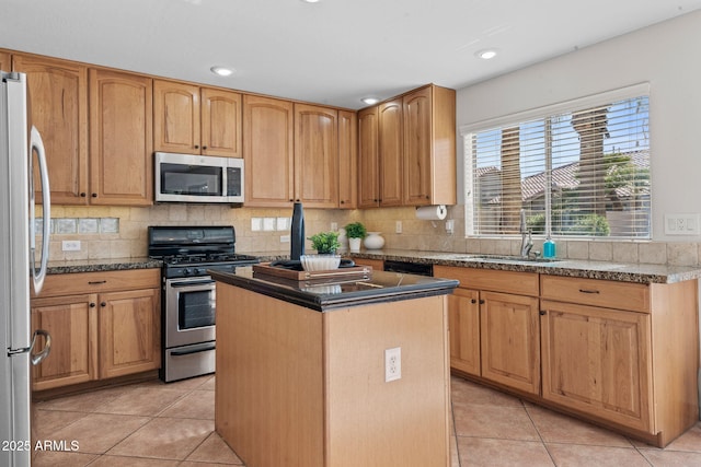 kitchen with a center island, light tile patterned floors, tasteful backsplash, appliances with stainless steel finishes, and sink