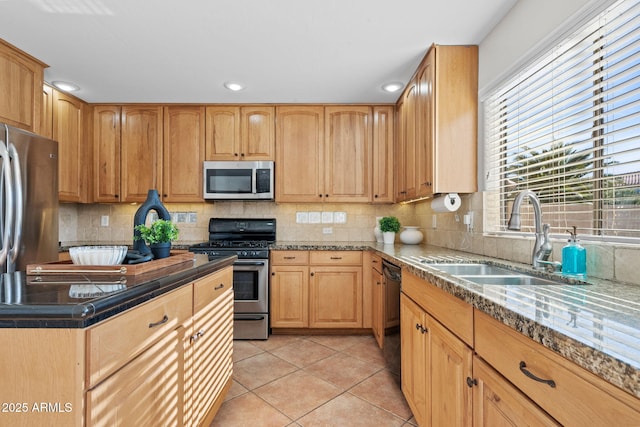 kitchen with appliances with stainless steel finishes, light tile patterned floors, tasteful backsplash, and sink