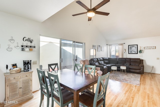 dining area featuring light wood-style flooring, high vaulted ceiling, and ceiling fan