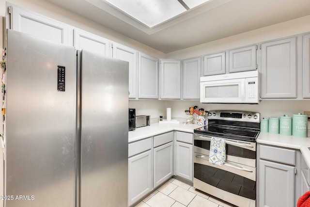 kitchen with light tile patterned floors, stainless steel appliances, and light countertops