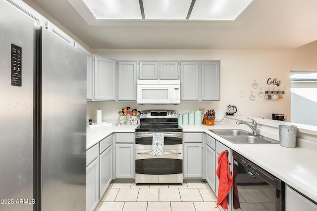 kitchen featuring a sink, light countertops, light tile patterned flooring, and stainless steel appliances