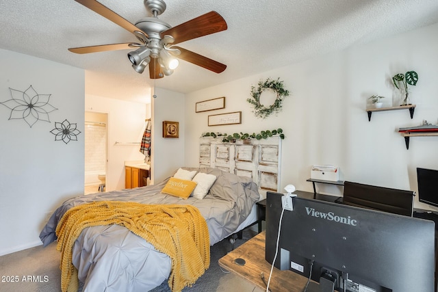 bedroom featuring baseboards, carpet, a textured ceiling, ensuite bath, and a ceiling fan