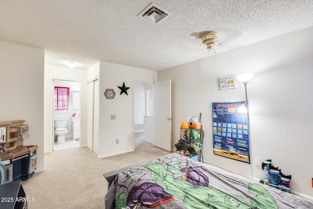 bedroom featuring baseboards, visible vents, a textured ceiling, light colored carpet, and connected bathroom