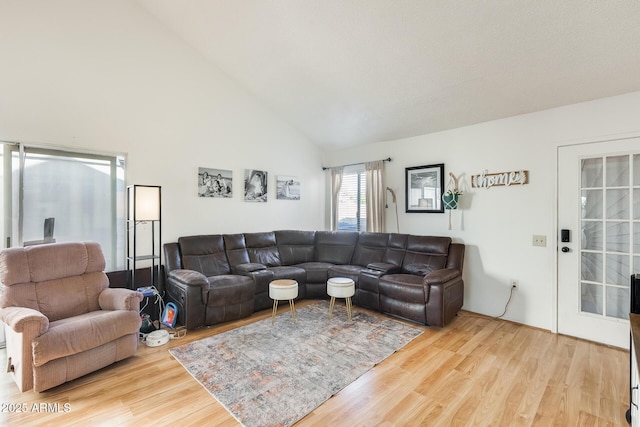 living room with wood finished floors and high vaulted ceiling