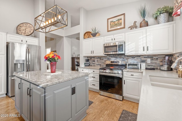4462 E Dale Ln, Cave Creek, AZ 85331 - kitchen with appliances with stainless steel finishes, a sink, a center island, white cabinetry, and a towering ceiling