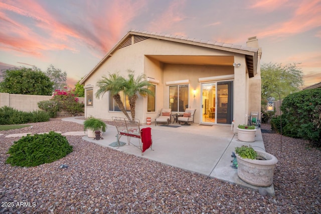 4462 E Dale Ln, Cave Creek, AZ 85331 - back of property at dusk featuring stucco siding, a patio, and a chimney