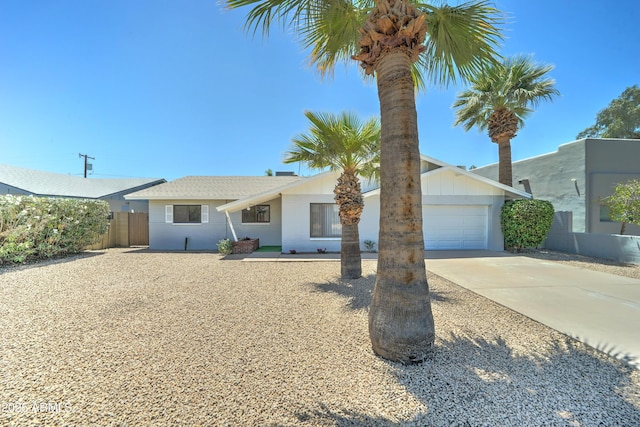 ranch-style house with concrete driveway, fence, and a garage