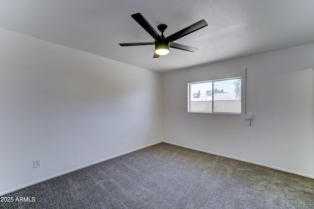 carpeted spare room featuring a ceiling fan and baseboards