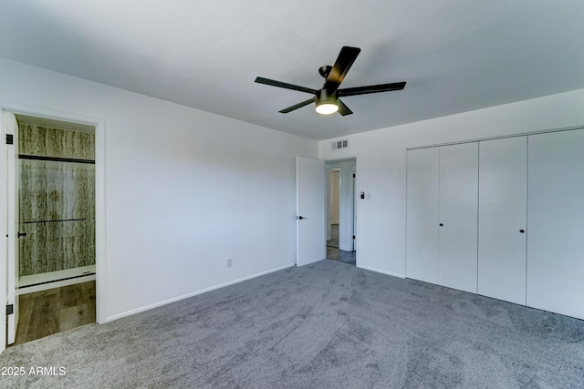 unfurnished bedroom featuring carpet, ensuite bath, baseboards, a closet, and ceiling fan