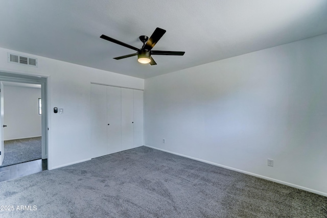 unfurnished bedroom with carpet, a closet, baseboards, and ceiling fan