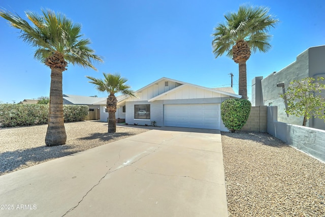 single story home with an attached garage, board and batten siding, concrete driveway, and fence