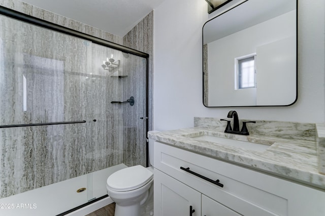 full bath with a stall shower, toilet, and vanity