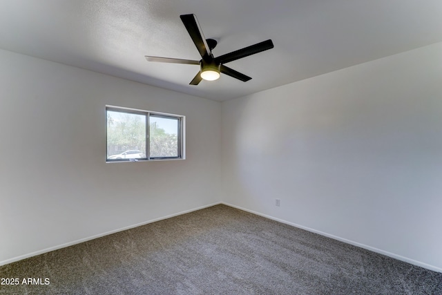 spare room featuring dark carpet, ceiling fan, and baseboards