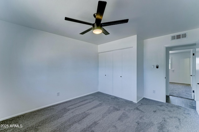 unfurnished bedroom featuring carpet floors, baseboards, a closet, and a ceiling fan