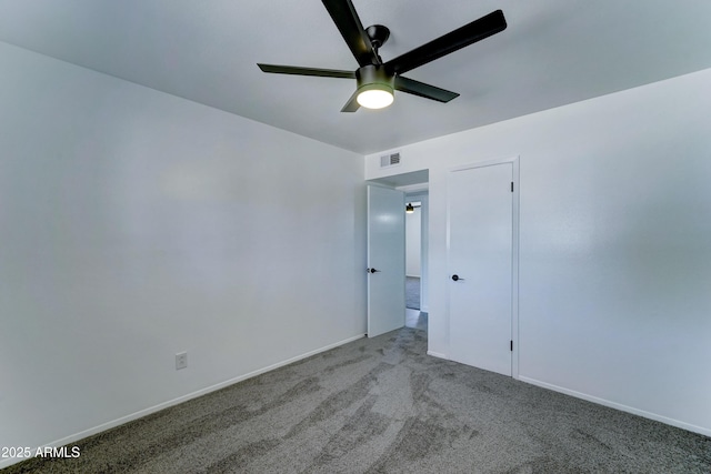 carpeted spare room with a ceiling fan and baseboards