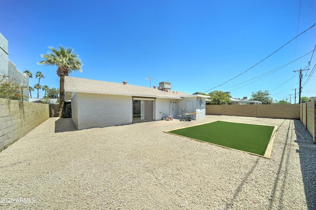 rear view of house with a fenced backyard, a patio area, and brick siding
