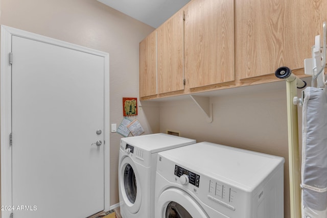 laundry area featuring washer and dryer and cabinets