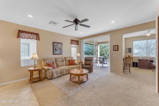 living room featuring ceiling fan, light tile patterned floors, and a wealth of natural light