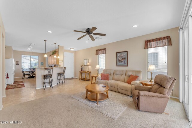 living room with a wealth of natural light, ceiling fan, and light tile patterned floors