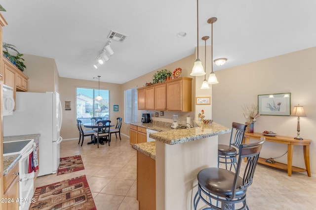 kitchen featuring pendant lighting, white appliances, kitchen peninsula, and a breakfast bar area