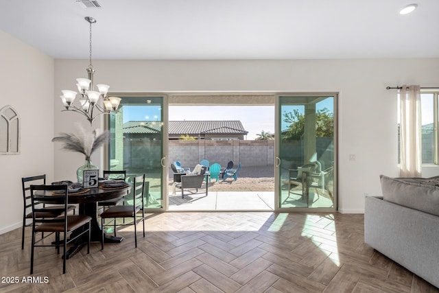 dining room with parquet floors, an inviting chandelier, and a wealth of natural light