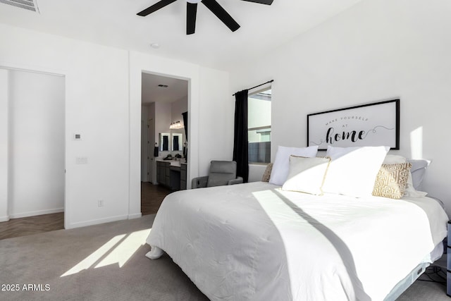 bedroom with ceiling fan, ensuite bathroom, and carpet