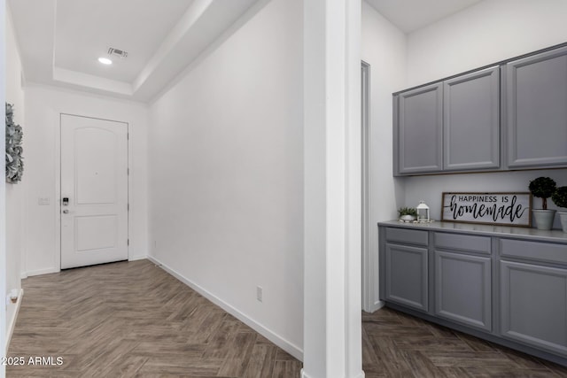 hallway with a raised ceiling and dark parquet floors