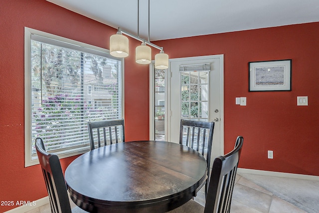 dining space with baseboards and light tile patterned flooring