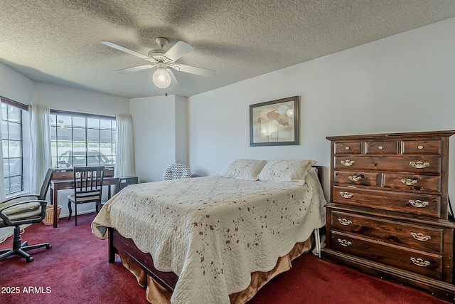 bedroom with dark colored carpet, a textured ceiling, and ceiling fan