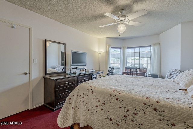 bedroom featuring ceiling fan, dark carpet, and a textured ceiling